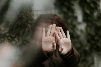 Vrouw verbergt gezicht achter handen